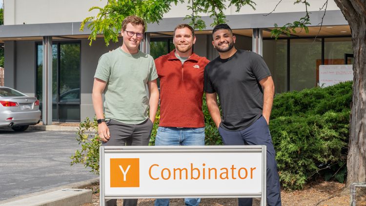 Picture of Taylor, John, and Michael standing behind the Y Combinator sign.
